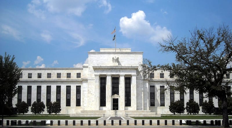Bagian luar Gedung Dewan Federal Reserve Marriner S. Eccles di Washington, D.C., bangunan marmer putih bergaya Art Deco di balik pepohonan