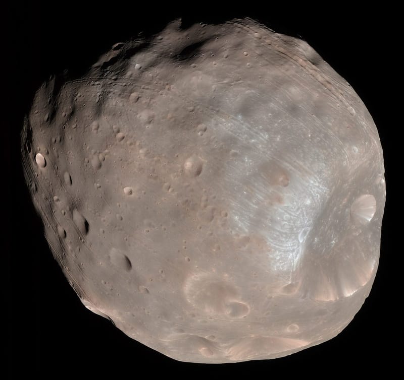Colour image of Mars' moon Phobos, a grey, irregular, heavily cratered body with the large Stickney crater visible