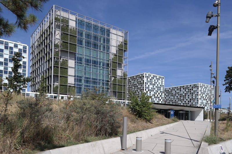 Exterior of the International Criminal Court building in The Hague, with its glass and pale stone towers, photographed in 2022