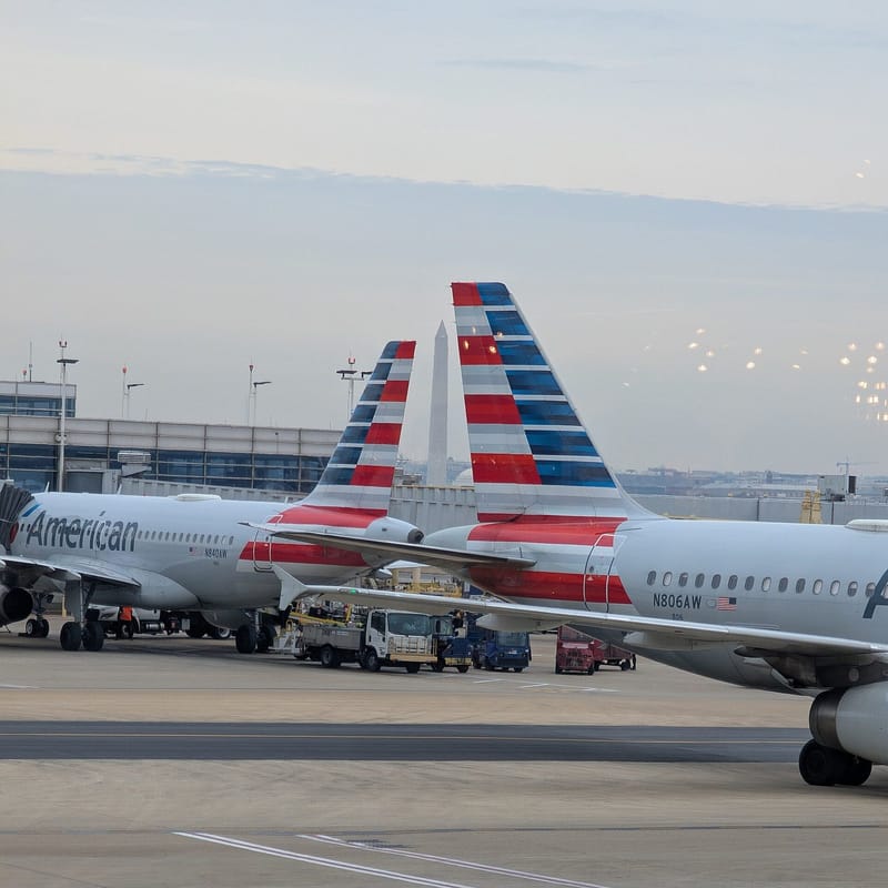 Tails of two American Airlines jets at Washington National Airport framing the Washington Monument
