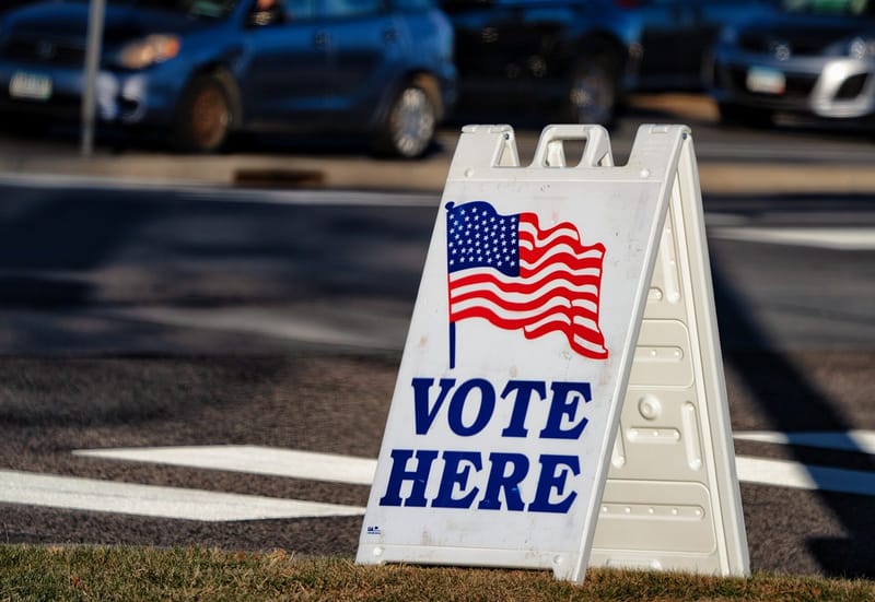 Vote Here sign outside a polling place at Woodbury City Hall, Minnesota, a state that bans deceptive election deepfakes within 90 days of a vote