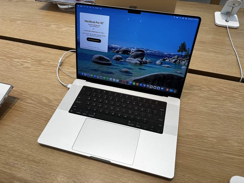 Silver Apple MacBook Pro from the previous M4 Pro generation, seen from above with macOS on screen; the new M6 MacBook Pro also comes in silver